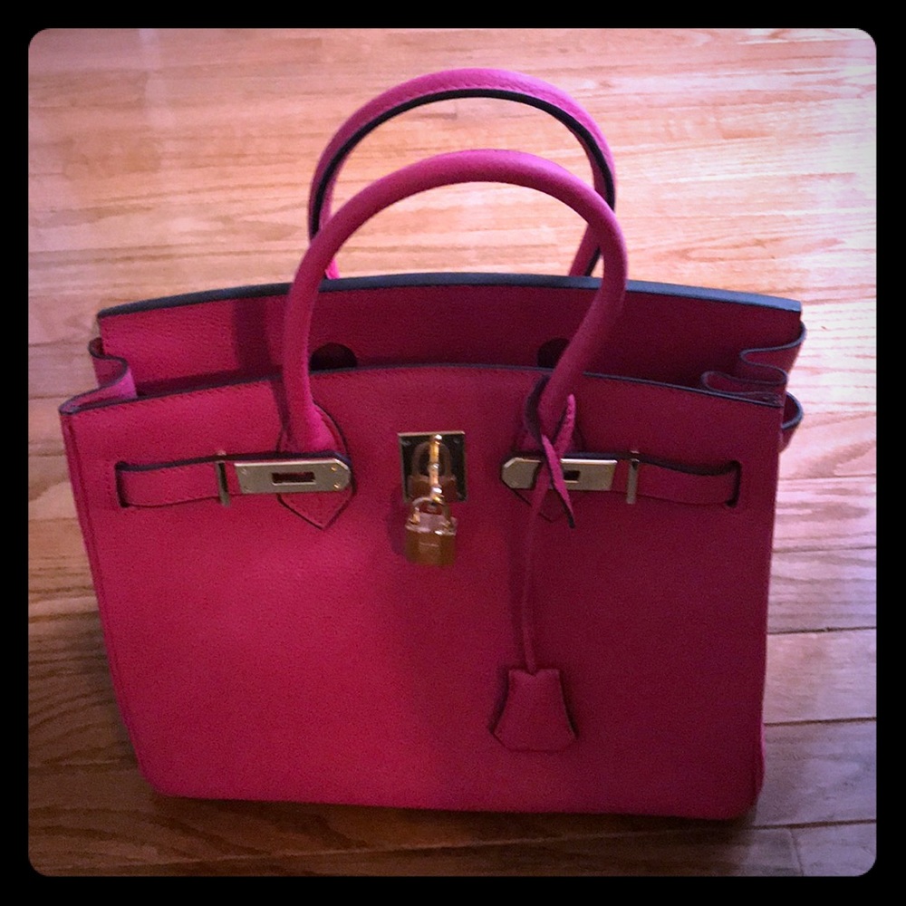 Hot pink, leather, handbag with gold trim.